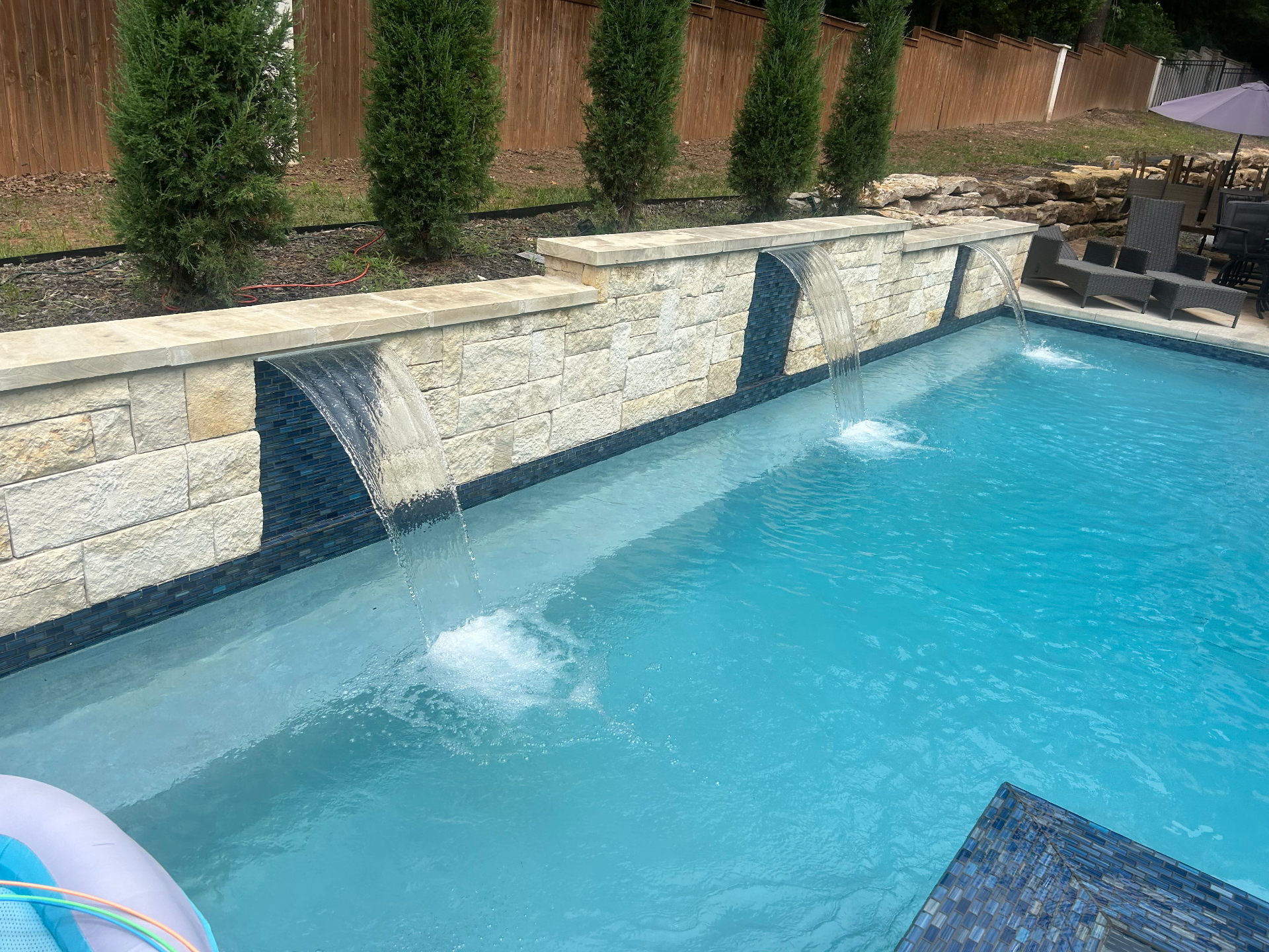 Backyard pool with stone waterfall feature in Tulsa